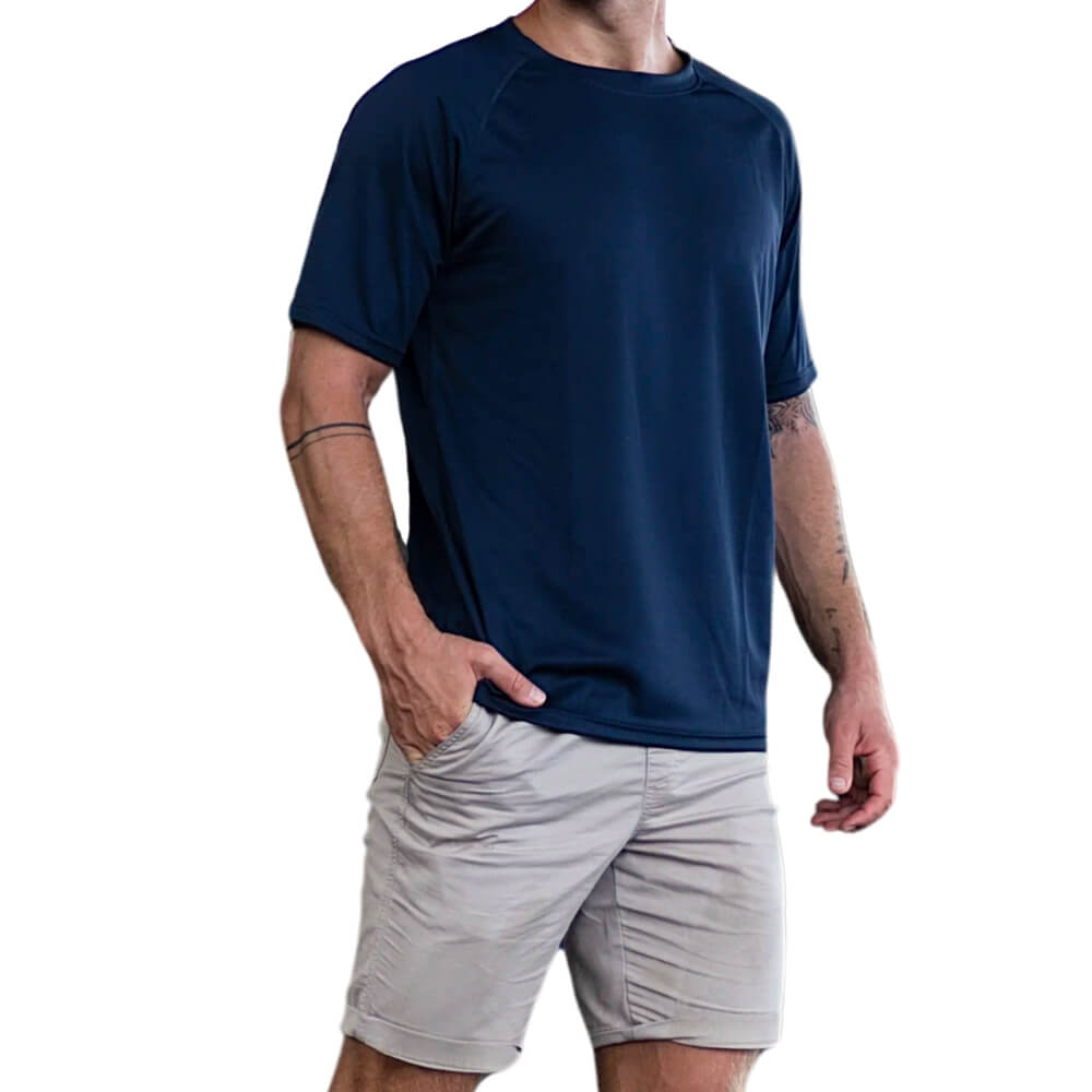 Mann posiert in marineblauem Funktionsshirt mit grauen Shorts, freigestellter Hintergrund.