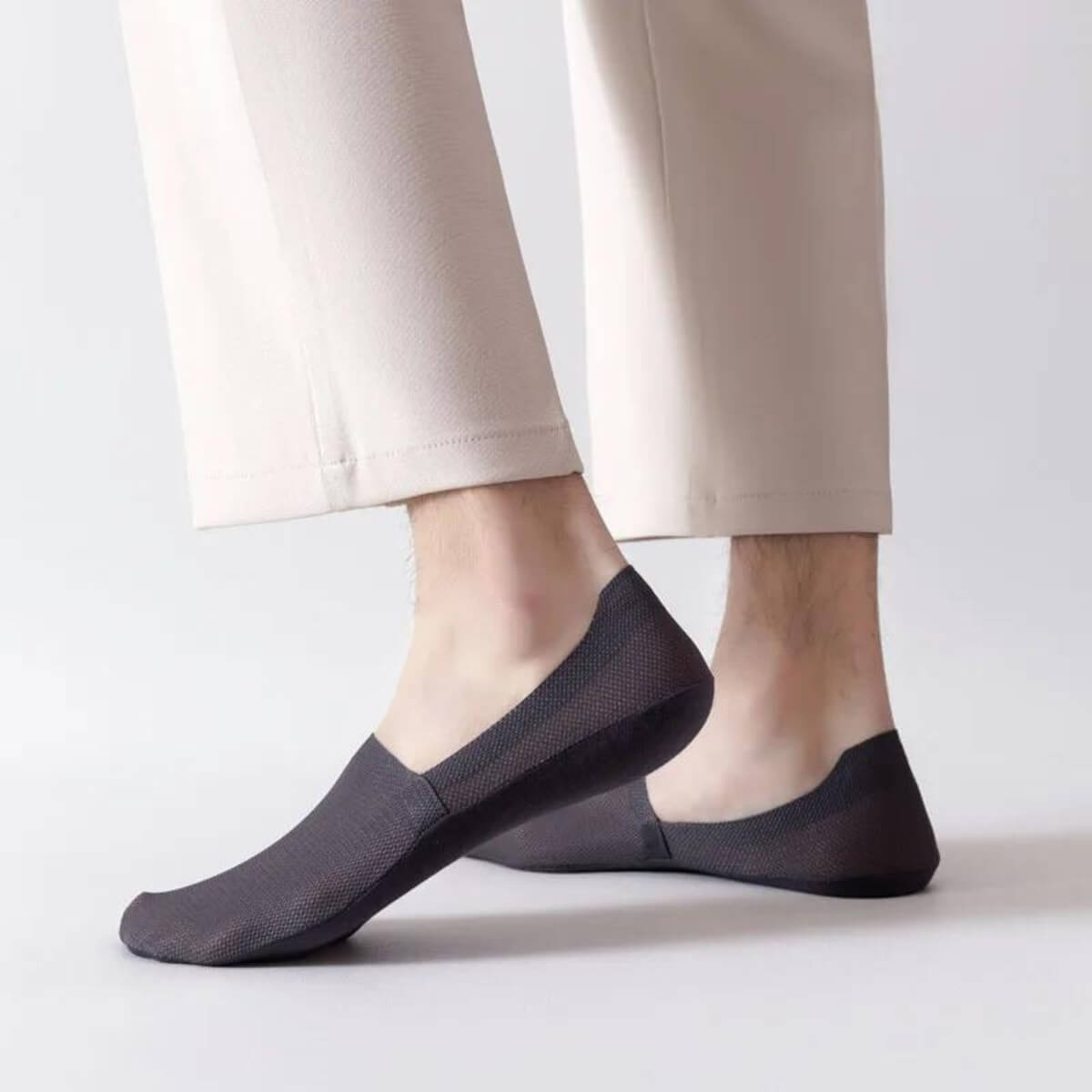 Schwarze Socken an den Füßen, lässig getragen mit beige Hose.