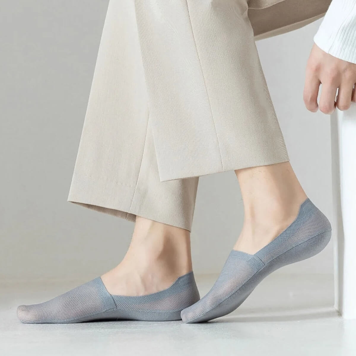 Blaue Socken an den Füßen, getragen mit beige Hose.