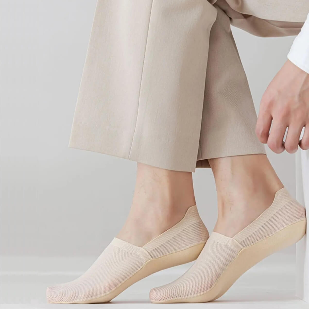 Beige Socke in Nahaufnahme, passend zu eleganter, heller Hose.