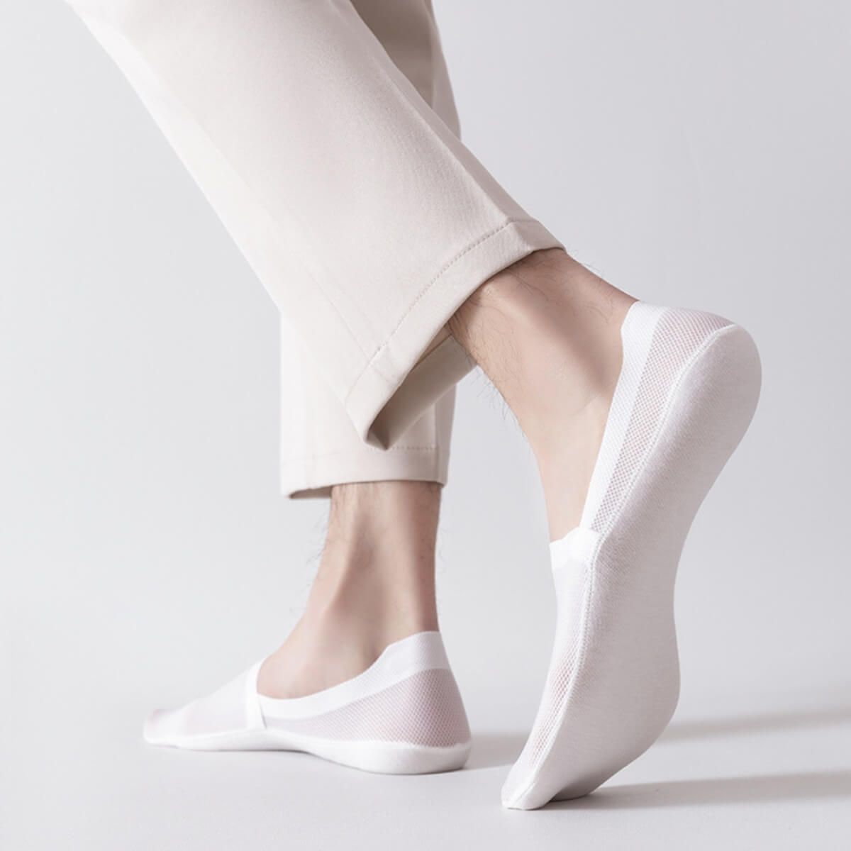 Weiße Socken mit dehnbarem Mesh-Design, getragen mit heller Hose.