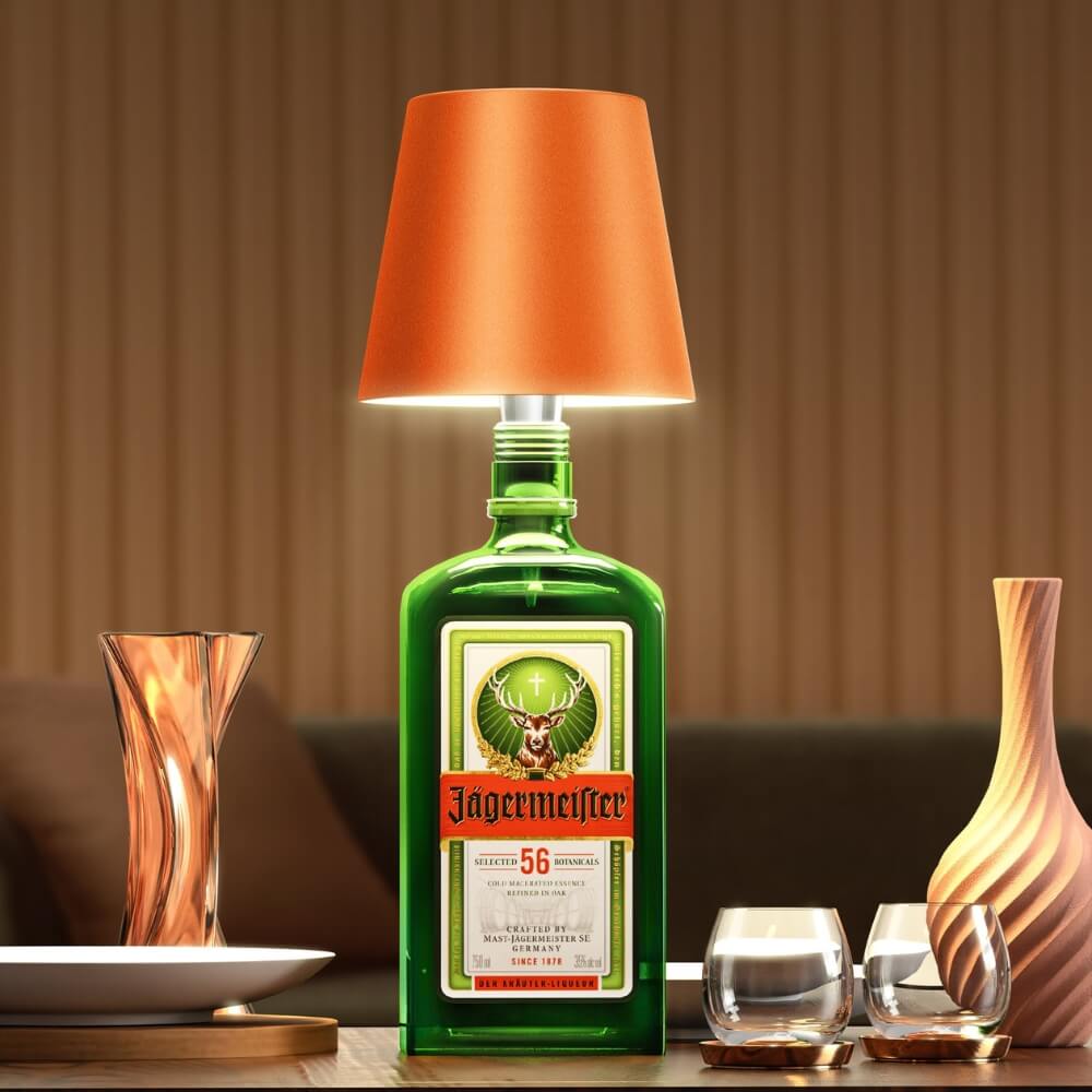 LED-Flaschenlampe mit orangefarbenem Lampenschirm auf einer Jägermeister-Flasche, stilvolle Bar- und Wohnraumbeleuchtung.