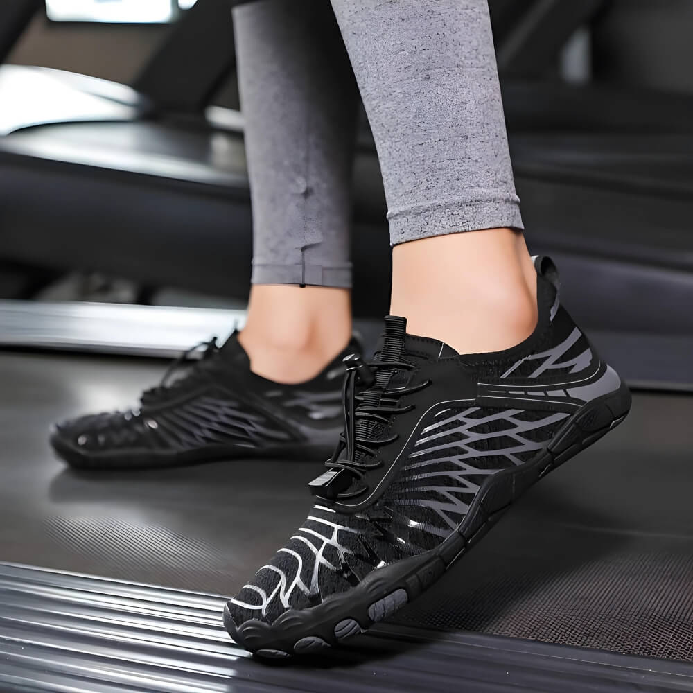 Barfußschuhe Schwarz/Grau auf dem Laufband. Ergonomisches Design für natürliche Bewegung und maximalen Komfort.