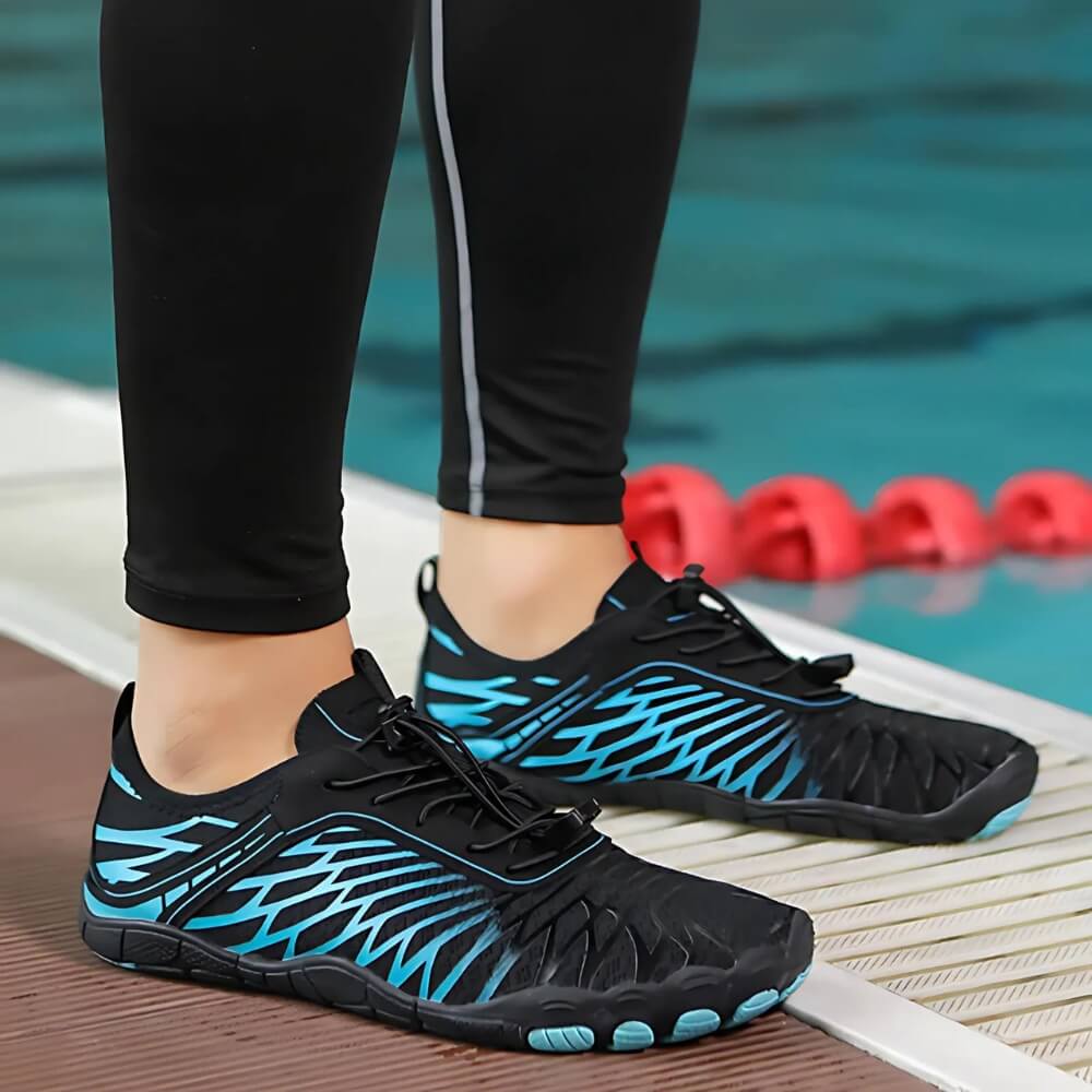 Barfußschuhe Schwarz/Türkis im Einsatz beim Wassersport. Leicht, flexibel und mit sicherem Halt auf nassen Oberflächen.